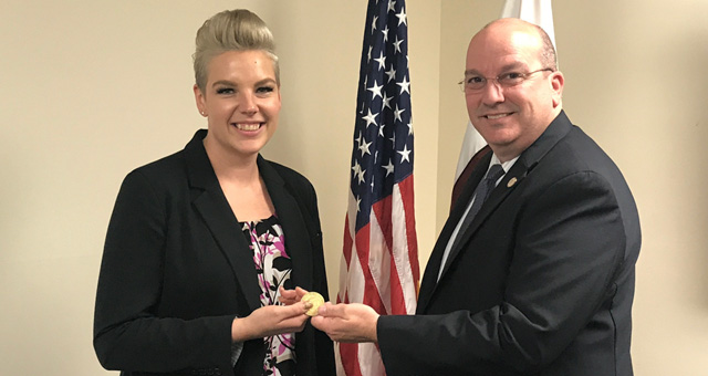 Amber George receiving the FLETA coin from Executive Director Joseph Collins