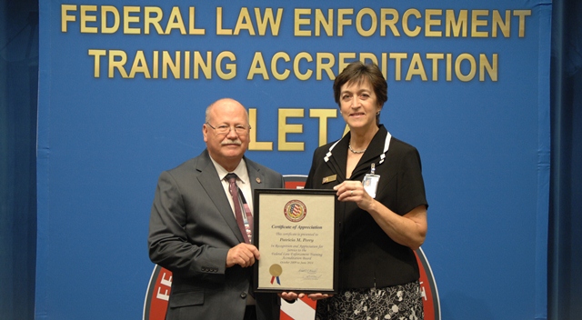 Executive Director Dr. Gary Mitchell presents Pat Perry with a certificate of appreciation for her service and support to the FLETA Board and Office of Accreditation.