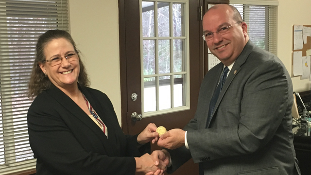Dr. Molly Wankel receives the FLETA coin from Executive Director Joe Collins