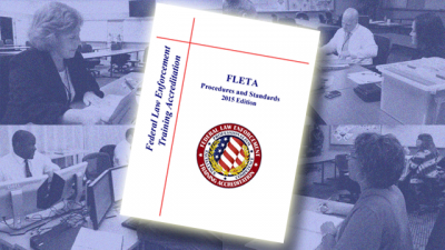Blue background with four photos of assessors reviewing files. The cover page of the Federal Law Enforcement Training Accreditation FLETA Procedures and Standards Manual 2015 with the FLETA seal sits on top of the photos