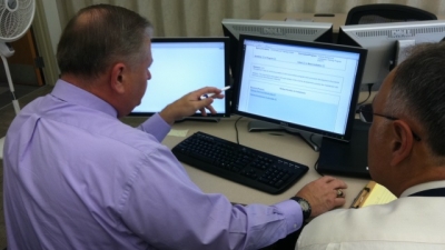 Assessors looking at materials on computer screens. Assessors looking at materials on computer screens.