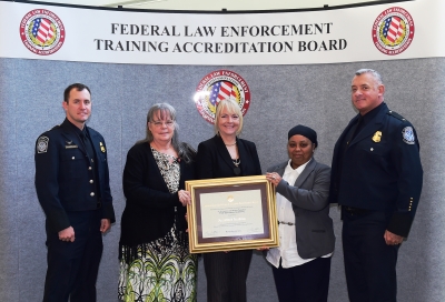 CBP Field Operations Academy staff accept the certificate for the academy accreditation.
