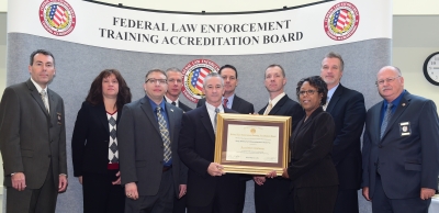 DEA staff accepts the certificate for Academy accreditation.