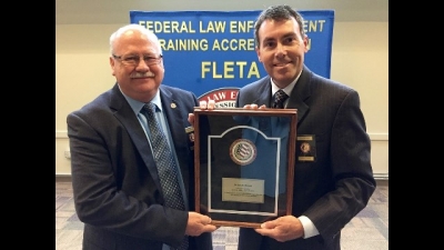 Dr. Gary Mitchell receives his retirement plaque from FLETA Board Chair Brian Peters