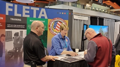 Christiana Halsey and Joe Collins speak with a visitor to the FLETA Booth