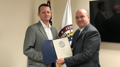 JJ Hensley (left) receives his 20-year certificate from Executive Director Joseph Collins