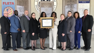 Representatives from the United States Immigration and Customs Enforcement hold the FLETA Accreditation Certificate Representatives from the United States Immigration and Customs Enforcement hold the FLETA Accreditation Certificate