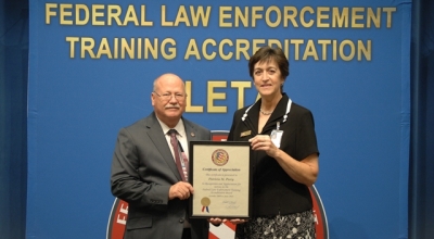 Executive Director Dr. Gary Mitchell presents Pat Perry with a certificate of appreciation for her service and support to the FLETA Board and Office of Accreditation. Executive Director Dr. Gary Mitchell presents Pat Perry with a certificate of appreciation for her service and support to the FLETA Board and Office of Accreditation.