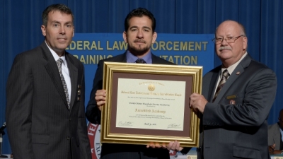 FLETA Board Chair Brian Peters (left) and FLETA Executive Director Gary Mitchell, Ph.D. present the accreditation certificate to the USMS Training Division FLETA Board Chair Brian Peters (left) and FLETA Executive Director Gary Mitchell, Ph.D. present the accreditation certificate to the USMS Training Division