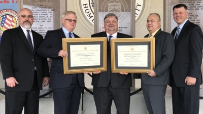 Members from the United States Secret Service hold the two FLETA Accreditation Certificates